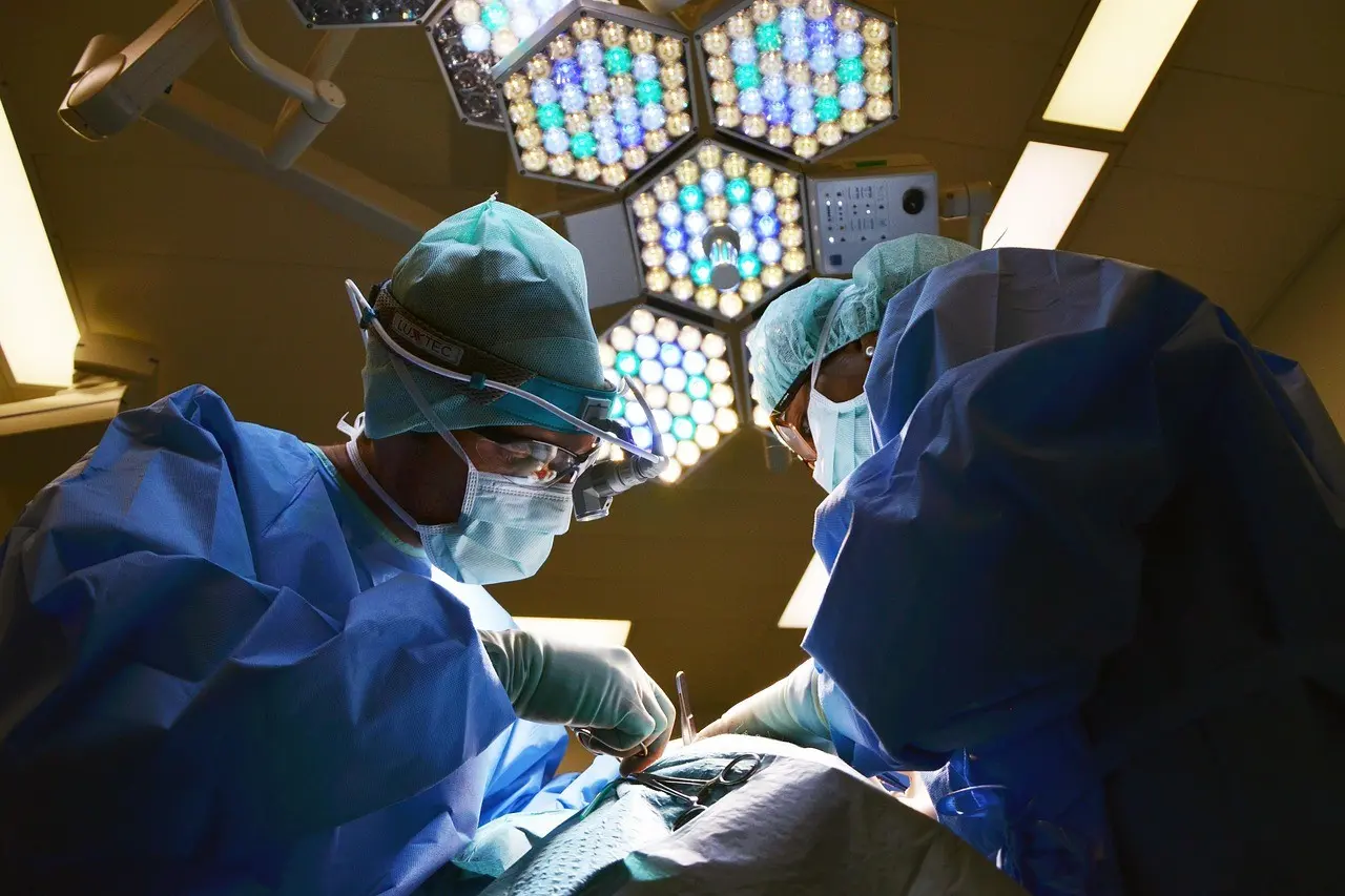 Dwóch lekarzy w niebieskich fartuchach przeprowadza operację.